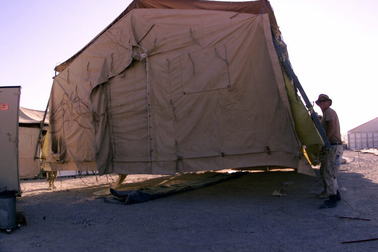 Taking advantage of the lightweight yet ridge structure of the TEMPER (Tent Extendable Modular Personnel) tent, a handful of 355th AEG (Air Expeditionary Group) personnel pick it up and move it into position to stake it down.  Several hundred tents are in place for military members deployed to Masirah Air Base, Oman in support of Operation ENDURING FREEDOM. In response to the terrorist attacks on September 11, 2001 at the New York World Trade Center and the Pentagon, President George W. Bush initiated Operation ENDURING FREEDOM in support of the Global War on Terrorism (GWOT), fighting terrorism abroad.